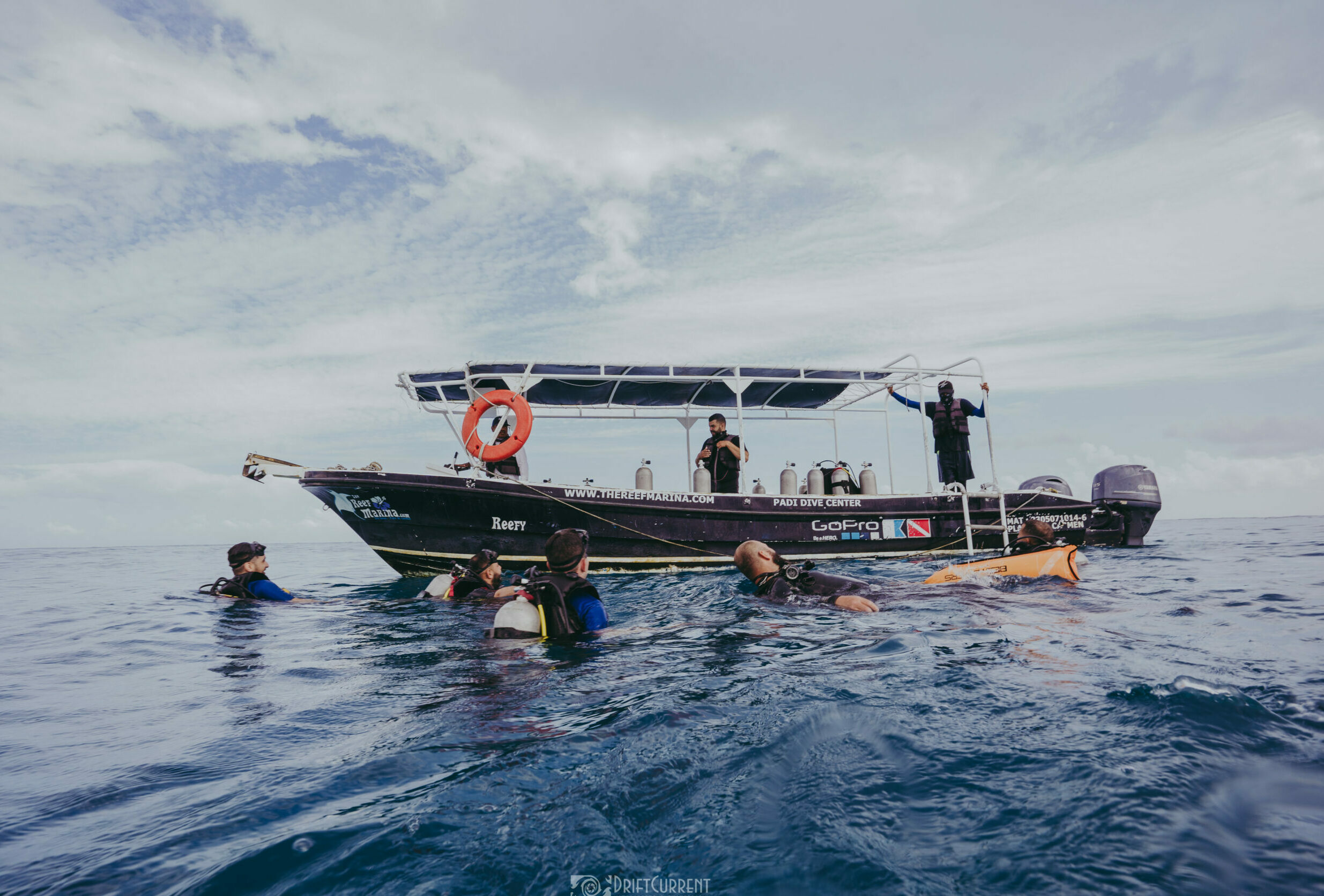 Plongeurs se regroupant autour du bateau Triton Diving après une plongée réussie à Playa del Carmen