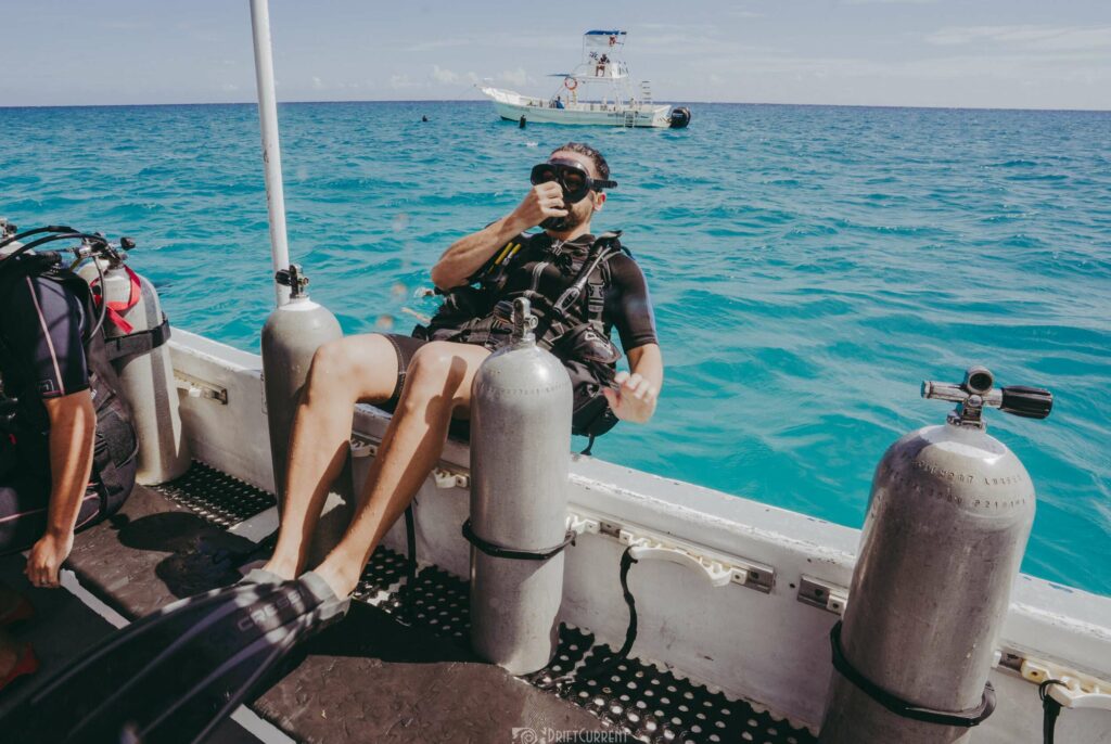 Diver from Triton Diving preparing for a backward roll entry into the turquoise waters of Playa del Carmen