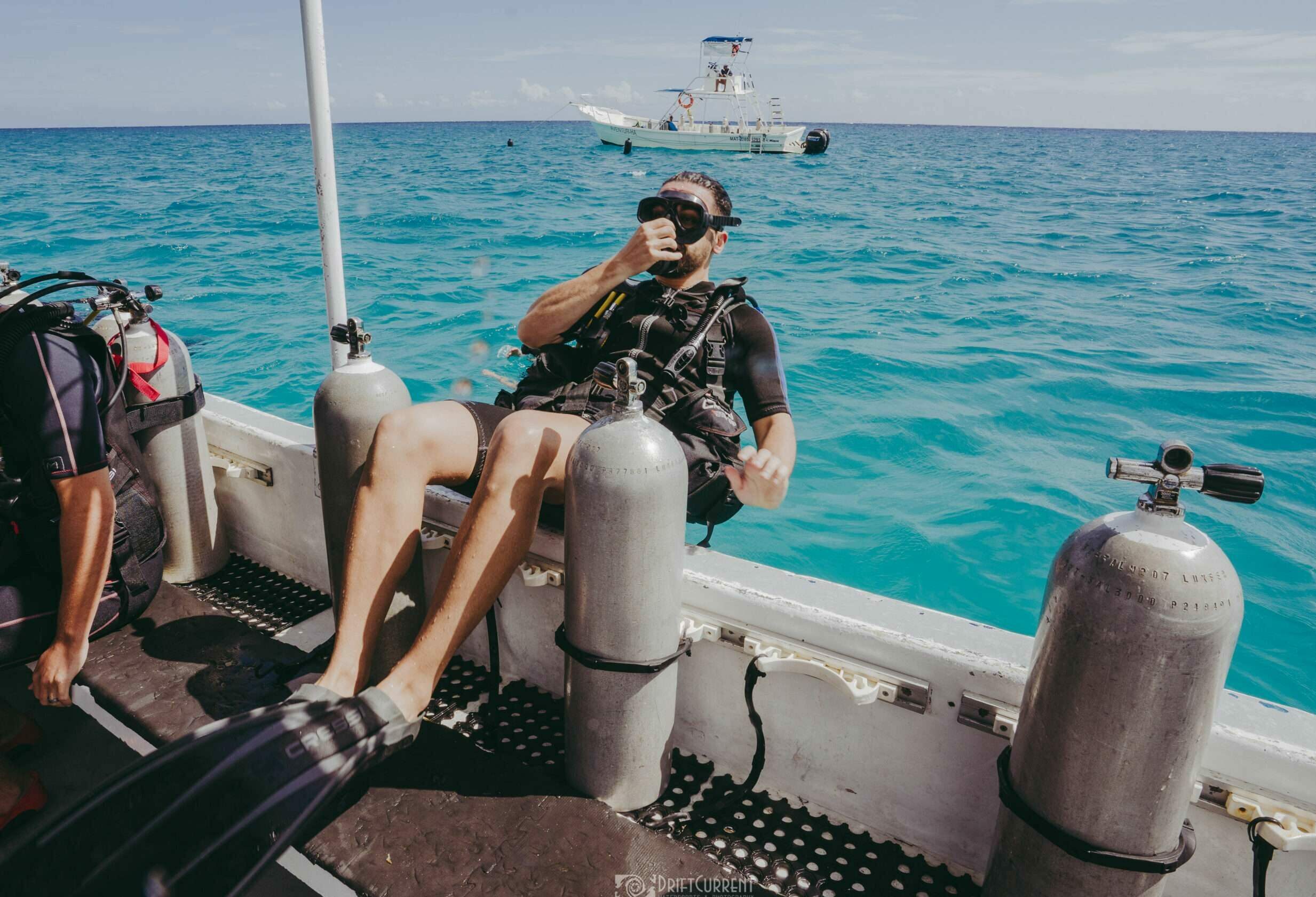 Plongeur de Triton Diving se préparant pour une entrée en bascule arrière dans les eaux turquoises de Playa del Carmen