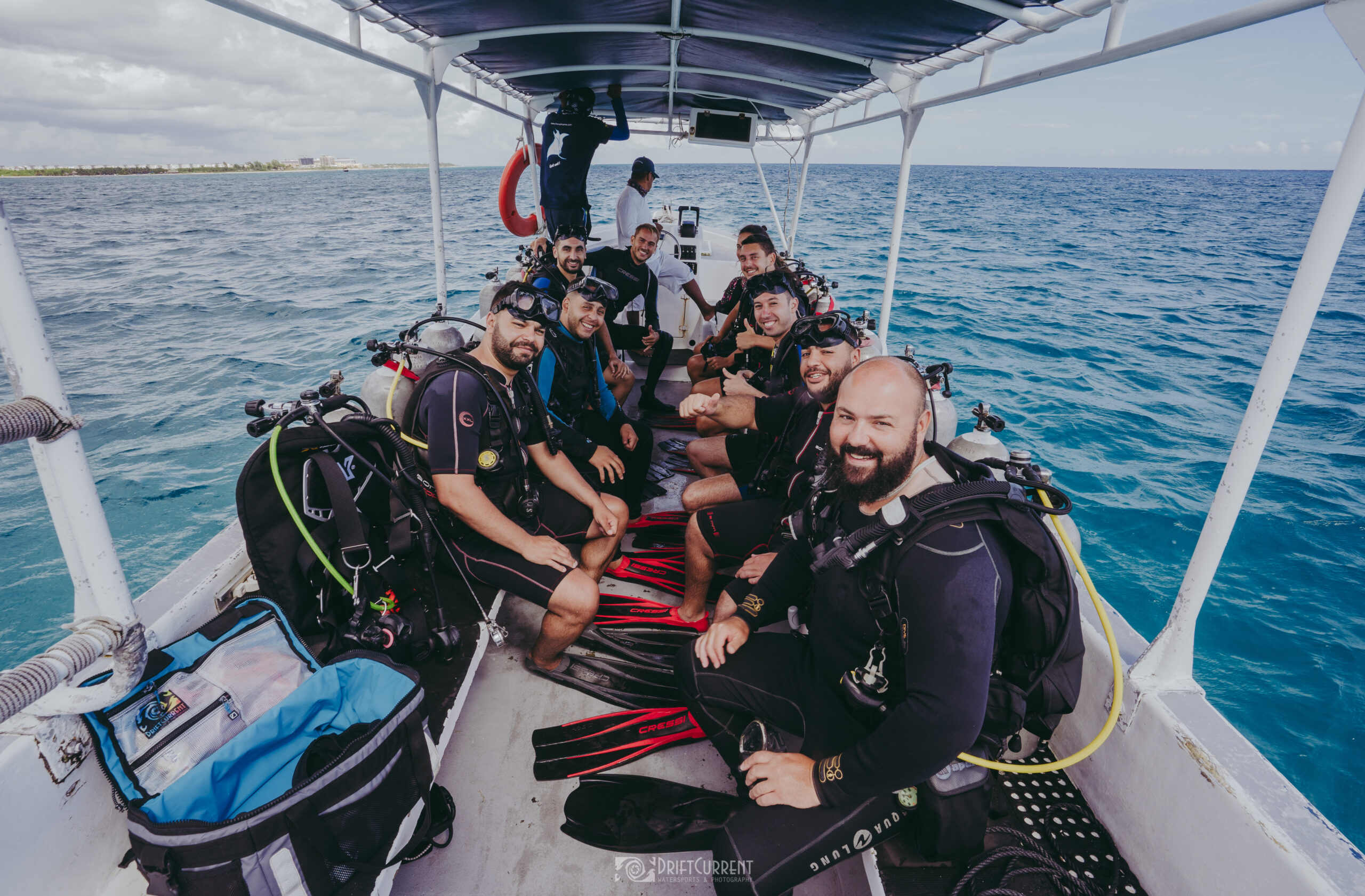 L'équipage de Triton Diving prêt pour la plongée à Playa del Carmen, démontrant la camaraderie et l'équipement de plongée lors d'une journée ensoleillée