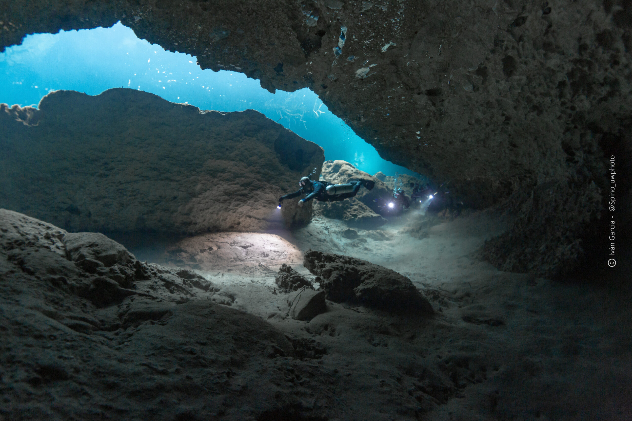 Plongeur de Triton Diving éclairant le chemin dans les eaux claires de Casa Cenote