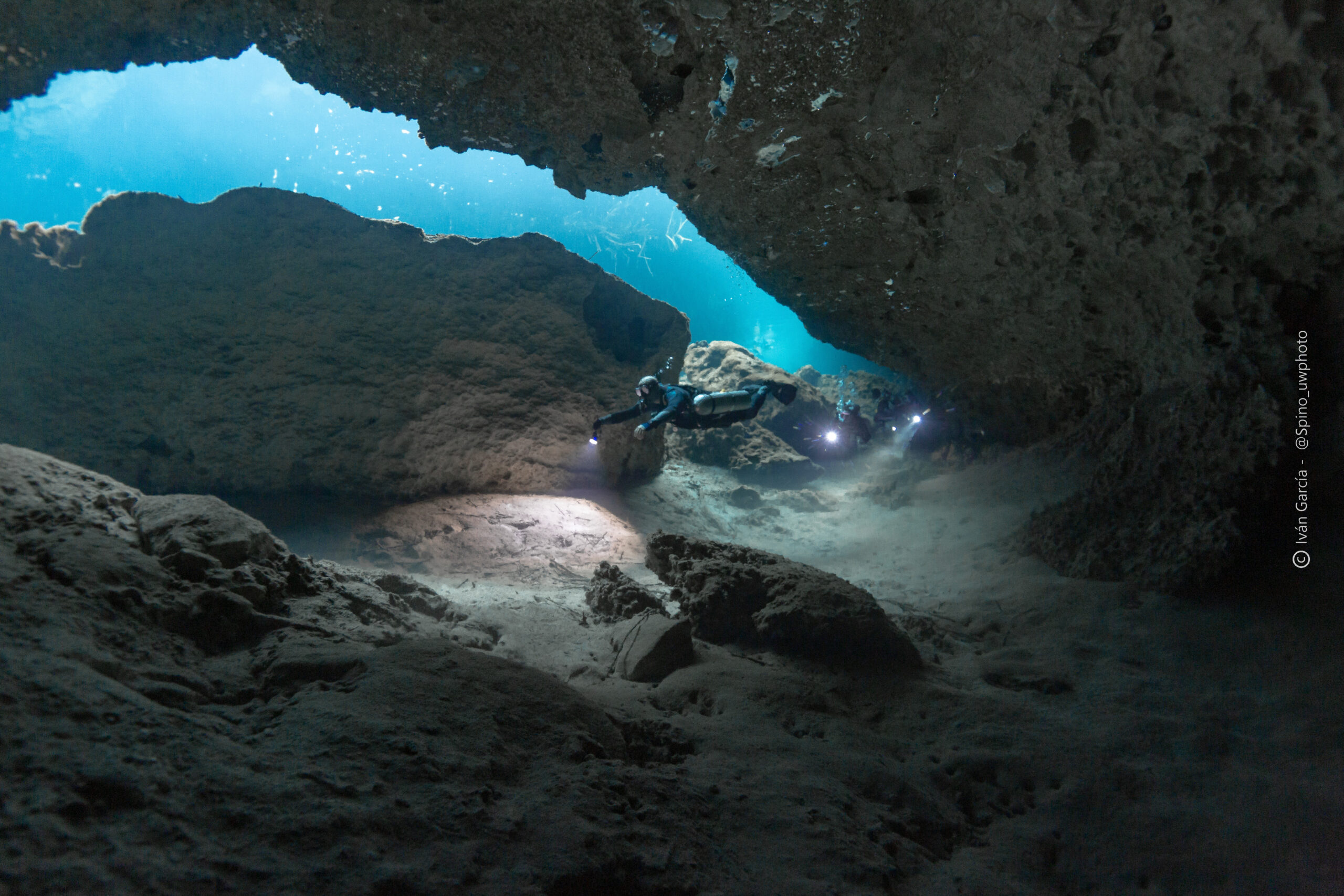 Plongeur de Triton Diving éclairant le chemin dans les eaux claires de Casa Cenote