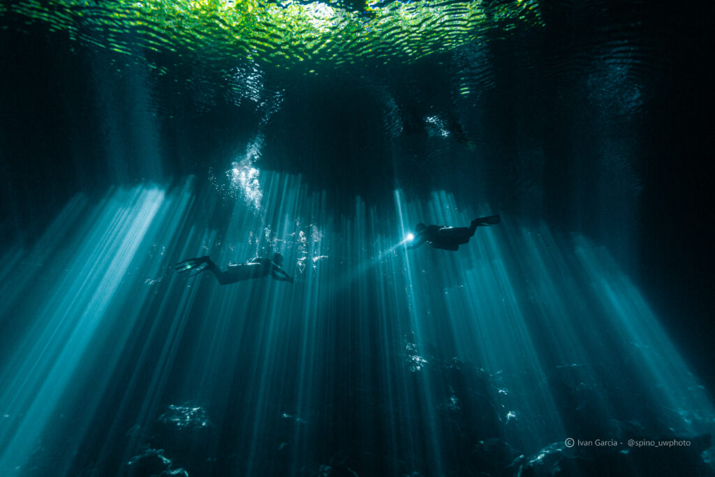 Les explorateurs de Triton Diving immergés dans les rayons de lumière surnaturels du Cénote Jardin del Eden