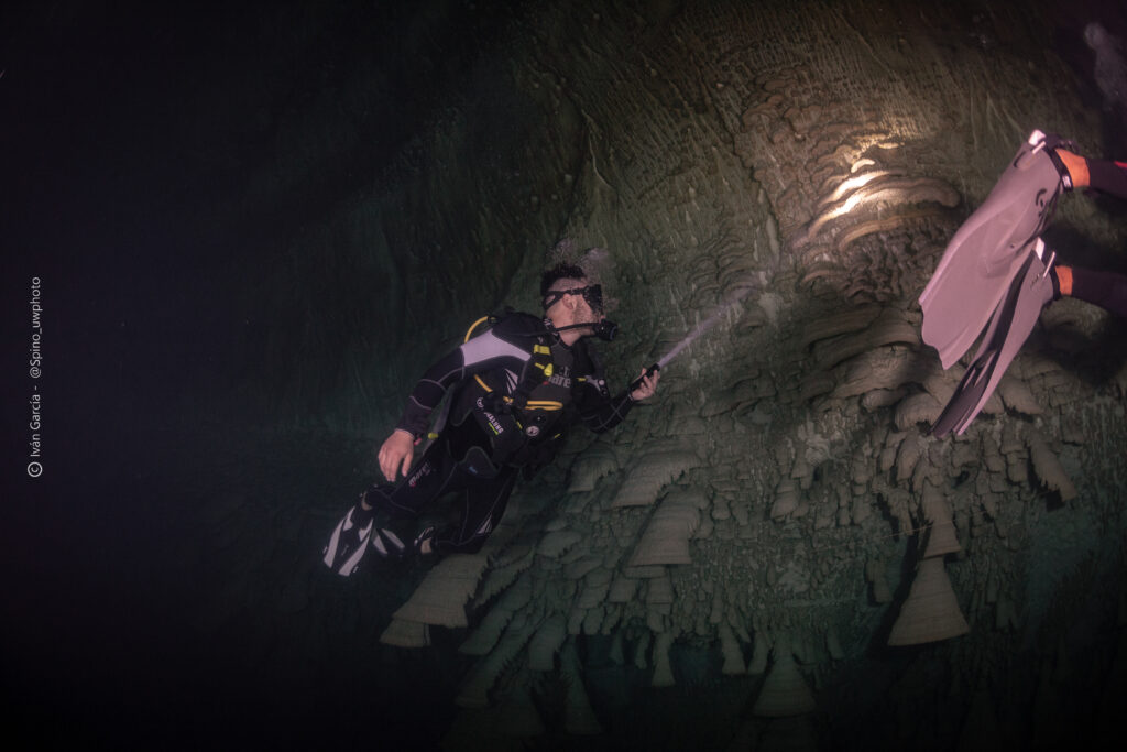 Triton Diving explorer admires the otherworldly formations within Cenote Zapote's depths