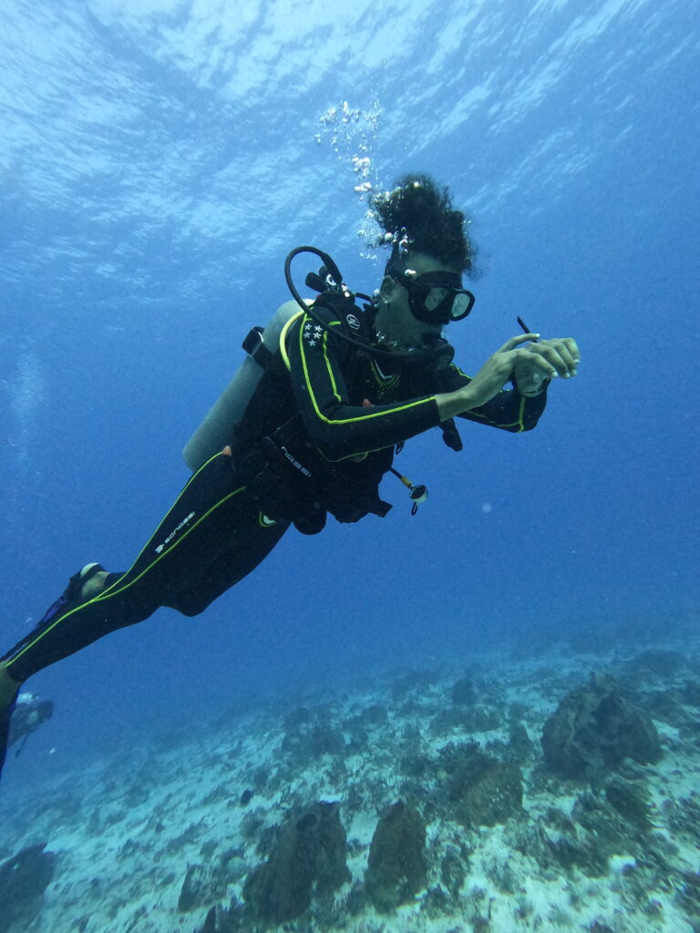 Instructeur Triton Diving lors d'un cours PADI Open Water à Playa del Carmen, vérifiant attentivement un ordinateur de plongée pour la sécurité.