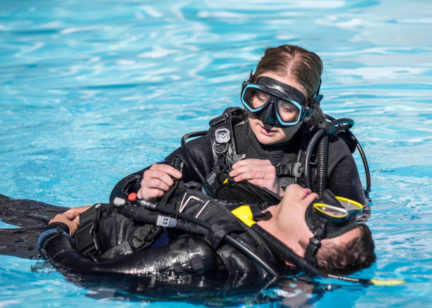Instructeur de Triton Diving effectuant un exercice de sauvetage, enlevant l'équipement d'un plongeur inconscient à la surface