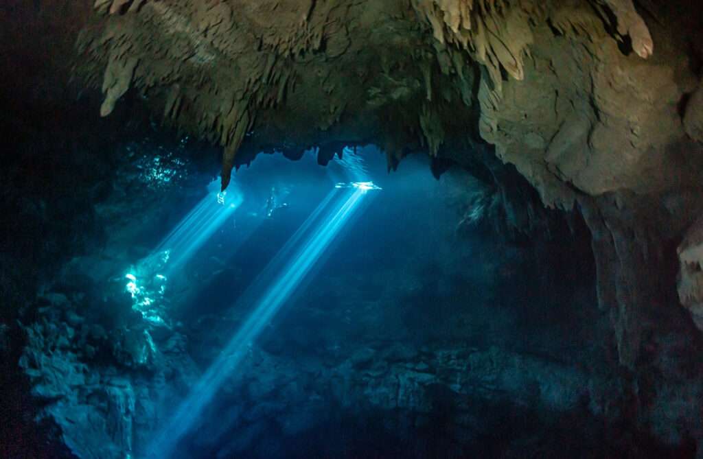 Light beams in the cave of Cenote The Pit
