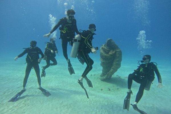 Groupe de Triton Diving vivant un baptême de plongée autour de la statue sous-marine de la Vierge à la Cueva del Pargo de Playa del Carmen